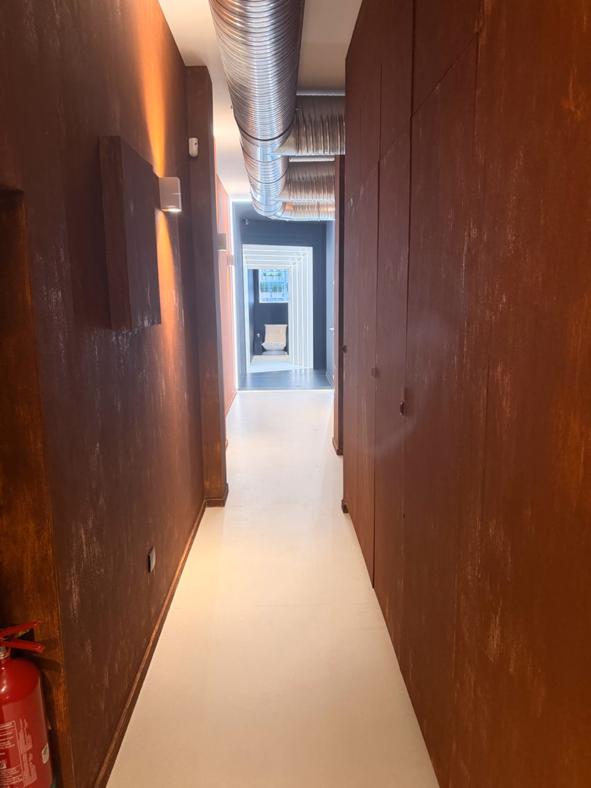 Extincteur CO2 fixé au mur d'un couloir desservant les cabines de soin dans un institut de beauté à Bordeaux