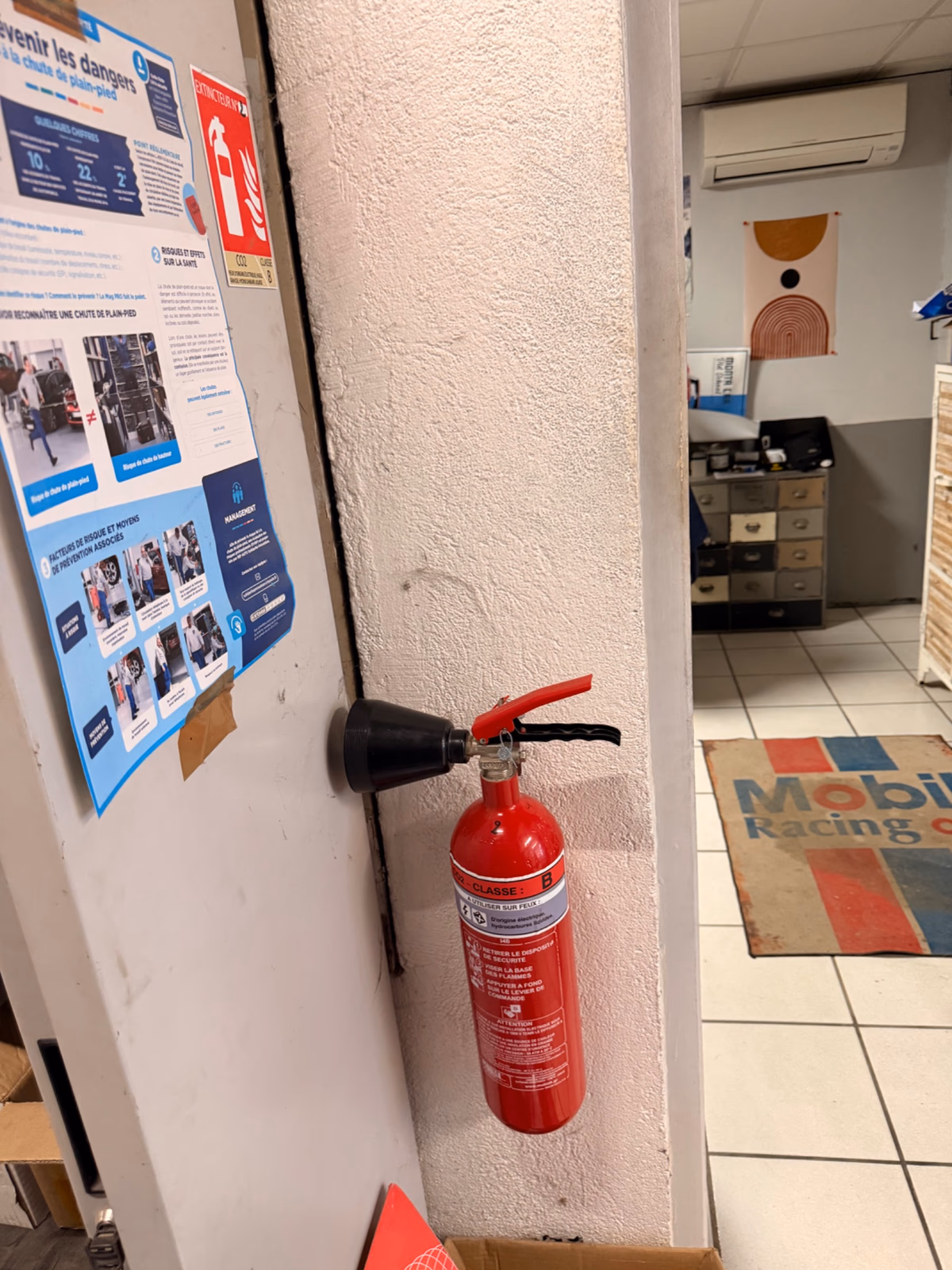 Extincteur CO2 2 kg fixé au mur près de l'accueil d'un magasin de pièces automobiles à Saint-André-de-Cubzac, installation FJ Fire