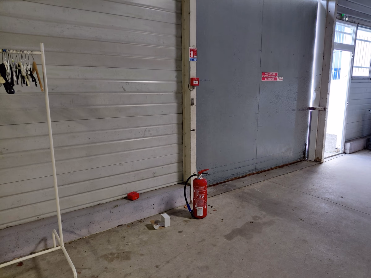 Technicien FJ Fire vérifiant un déclencheur manuel d'alarme incendie près d'une porte coupe-feu, salle de réception à Saint-Seurin-sur-l'Isle