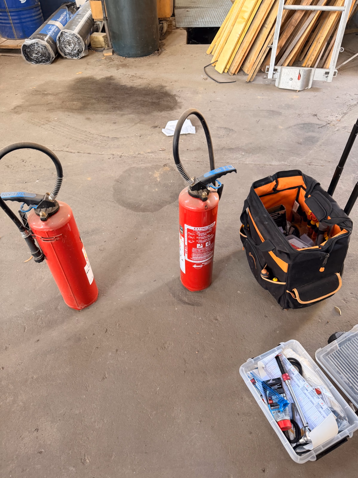 Vérification de plusieurs extincteurs dans l'atelier d'un charpentier couvreur zingueur à Guitres, dans le cadre d'une maintenance annuelle