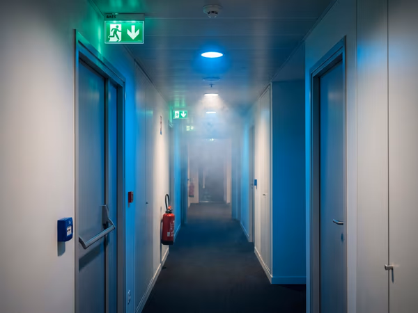 Bloc BAES lumineux de sécurité dans un couloir d'entreprise