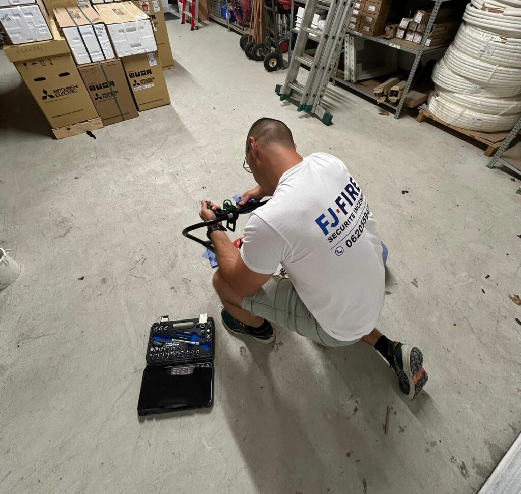 Un technicien FJ FIRE fait la maintenance d'un extincteur